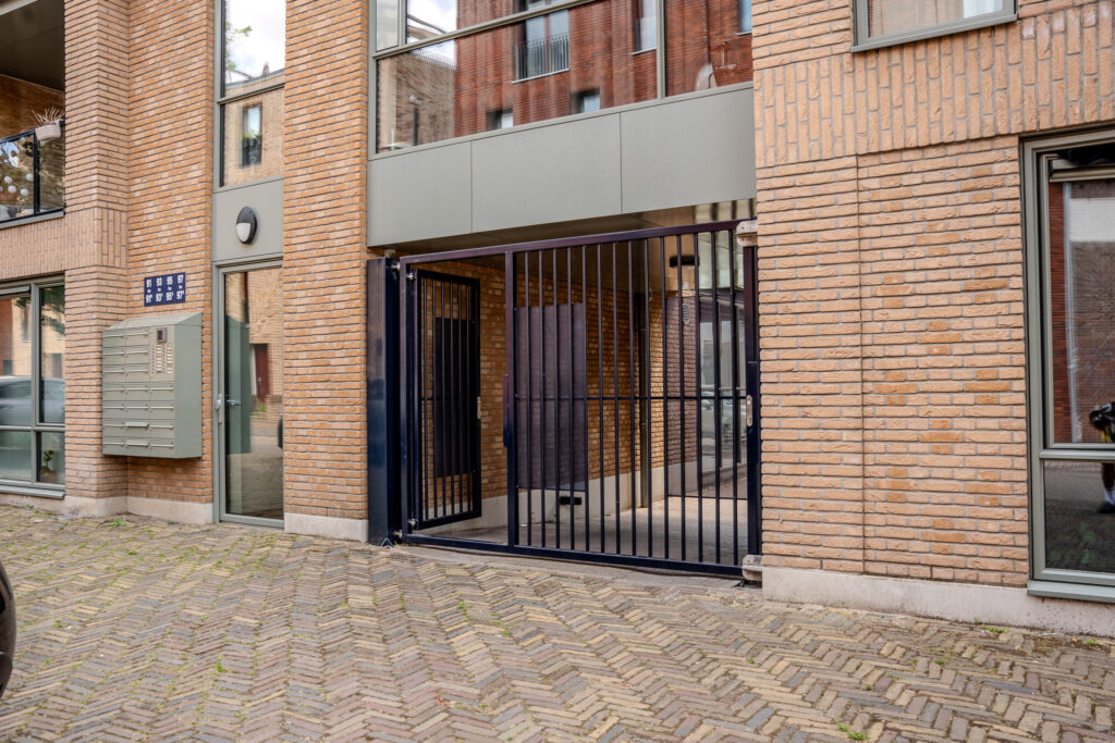 Moderne stalen poort met donkerblauwe afwerking